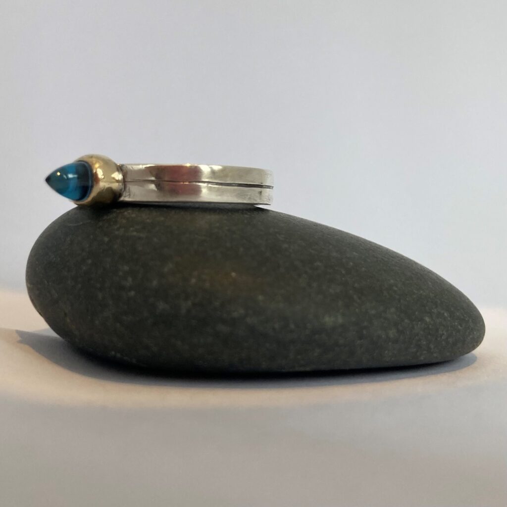Silver ring, gold setting, blue bullet shaped cabochon